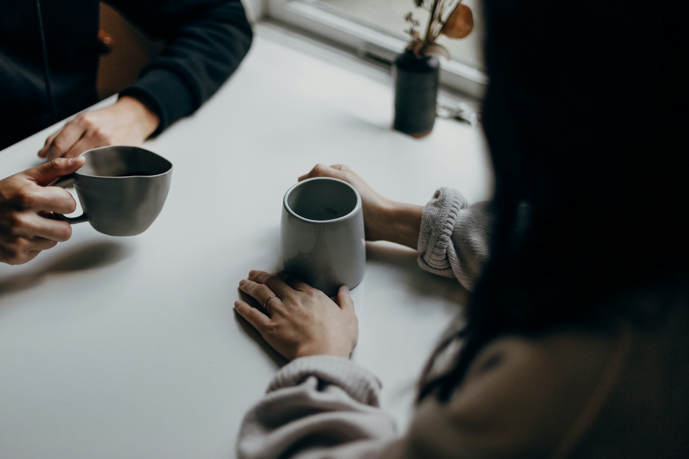 Two people talking over coffee at a table